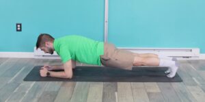 Dr. jon in an elbow or low plank preparing to push into his high plank for elbow to hand planks
